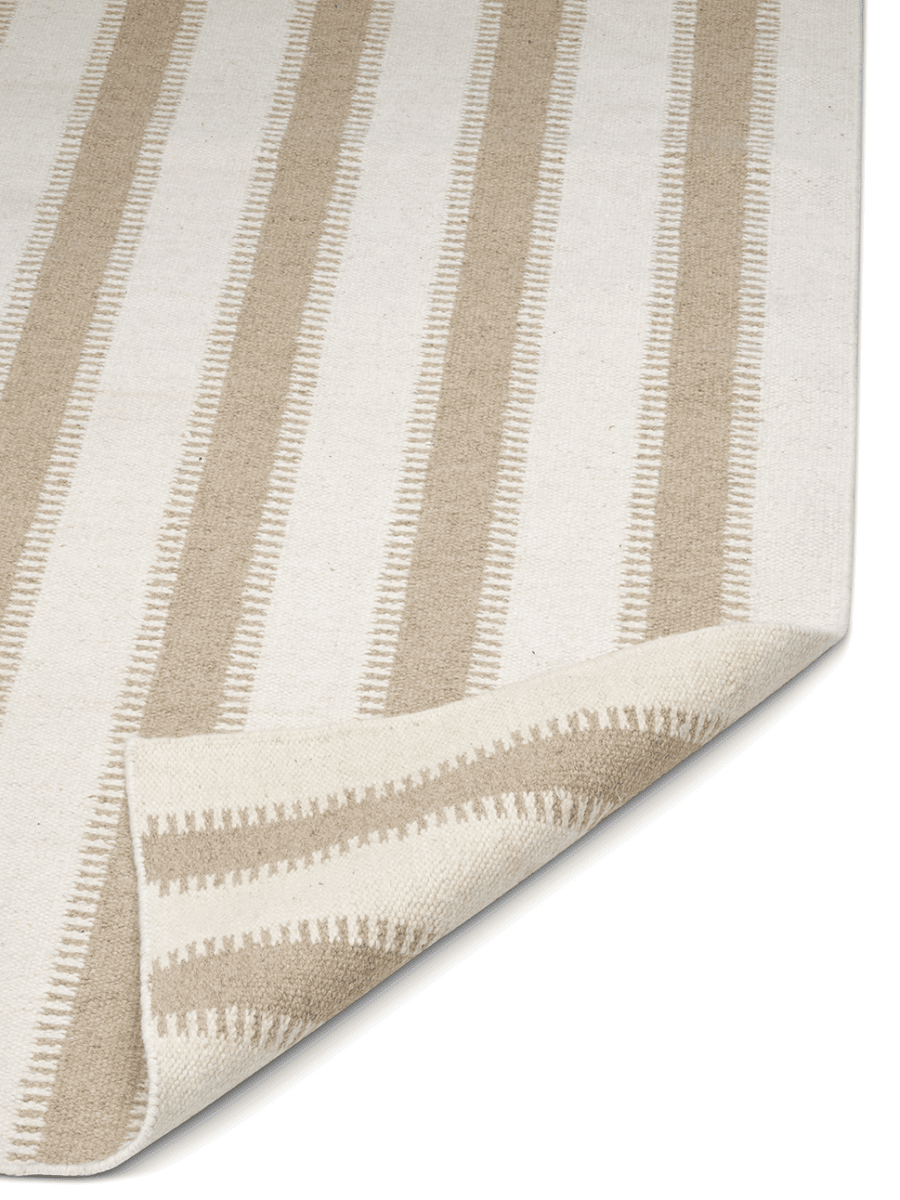 Randig matta i beige och naturvitt med vävd struktur och vikt hörn.