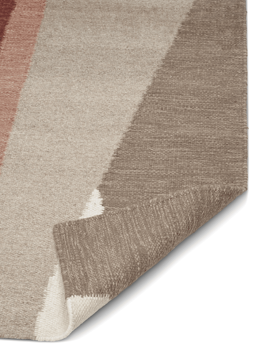 Vävd matta med geometriskt mönster i nyanser av beige, brunt och rostrött.
