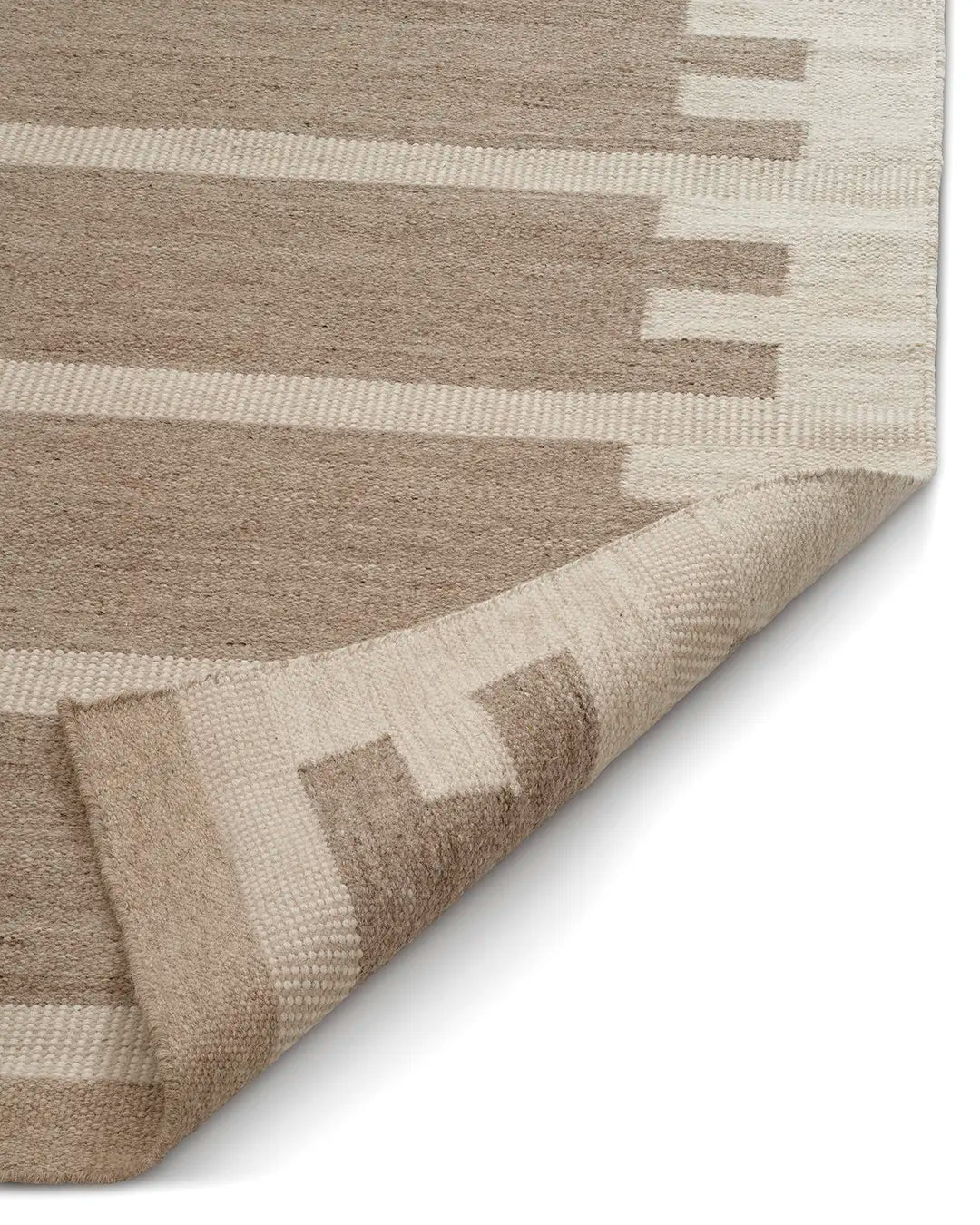 Beige matta med geometriskt mönster i ull med uppvikt hörn.