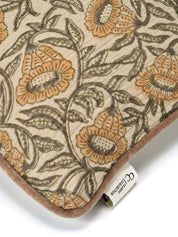 Kuddfodral Bell Yellow i handtryckt bomull med blommönster och pipingkant, frilagt mot vit bakgrund. Detaljbild av ett kuddhörn.