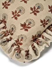 Kuddfodral Marigold Mocha i handtryckt bomull med mönster och volangkant, frilagt mot vit bakgrund. Detaljbild av ett kuddhörn.