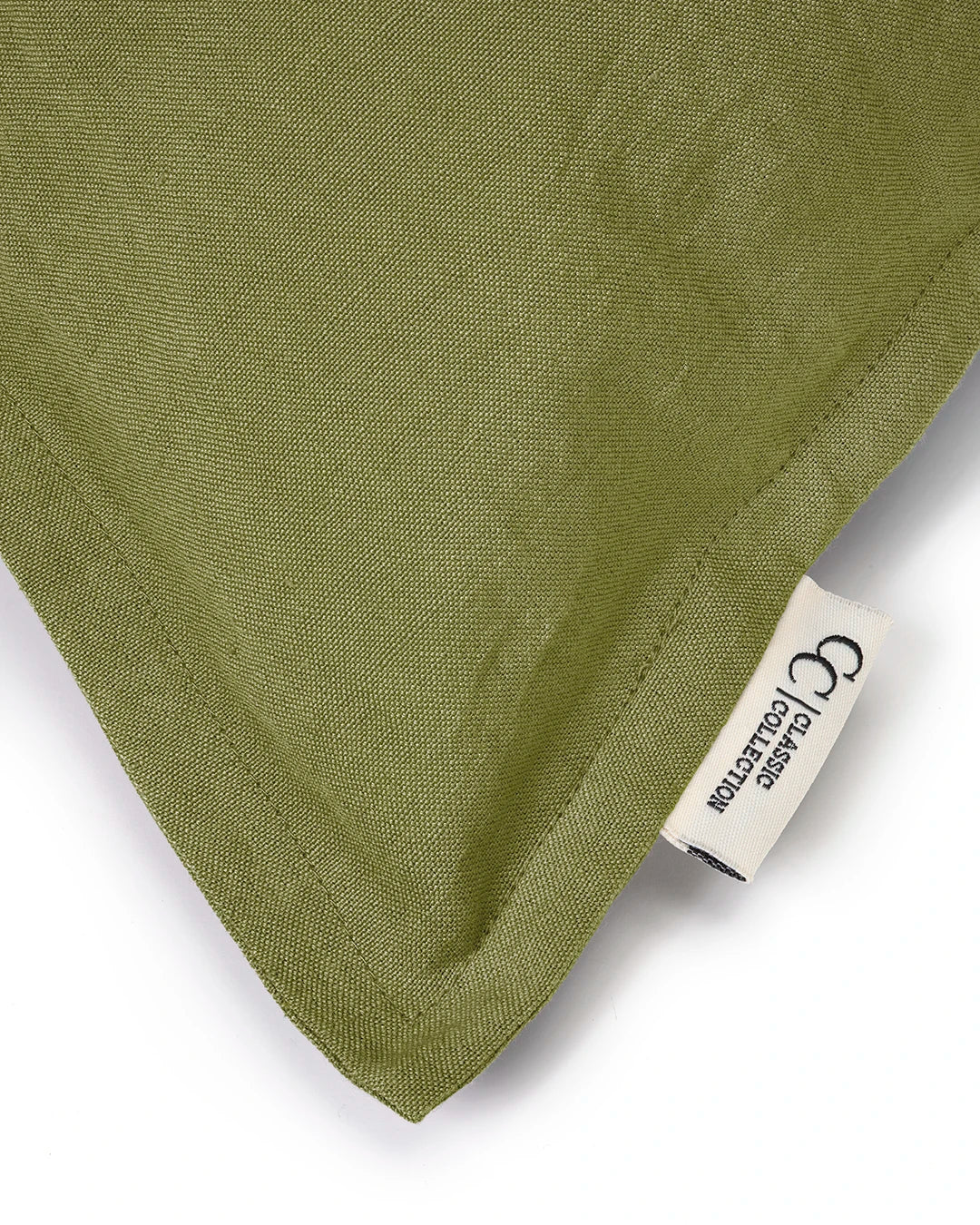 Olivgrönt kuddfodral i tyg med Classic Collection-etikett och synliga sömmar.