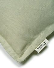 Närbild av kuddfodral Classic Linen Grön i linnetyg med kantdetalj och etikett från Classic Collection