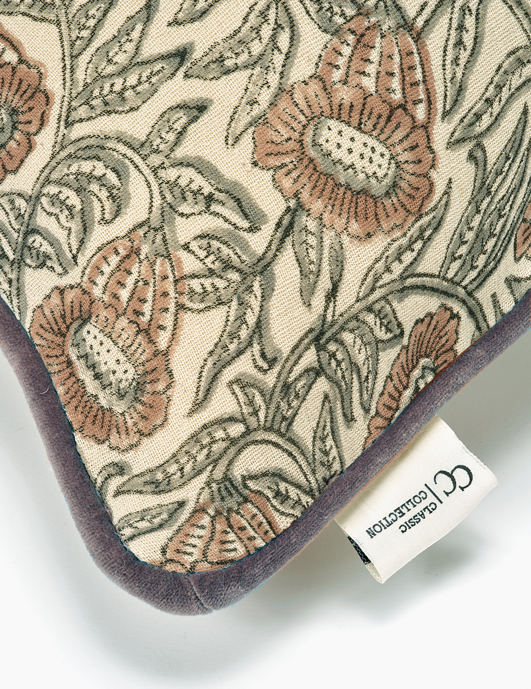 Närbild på Kuddfodral Bell Mocha med tryckt blommönster och sammetskant.