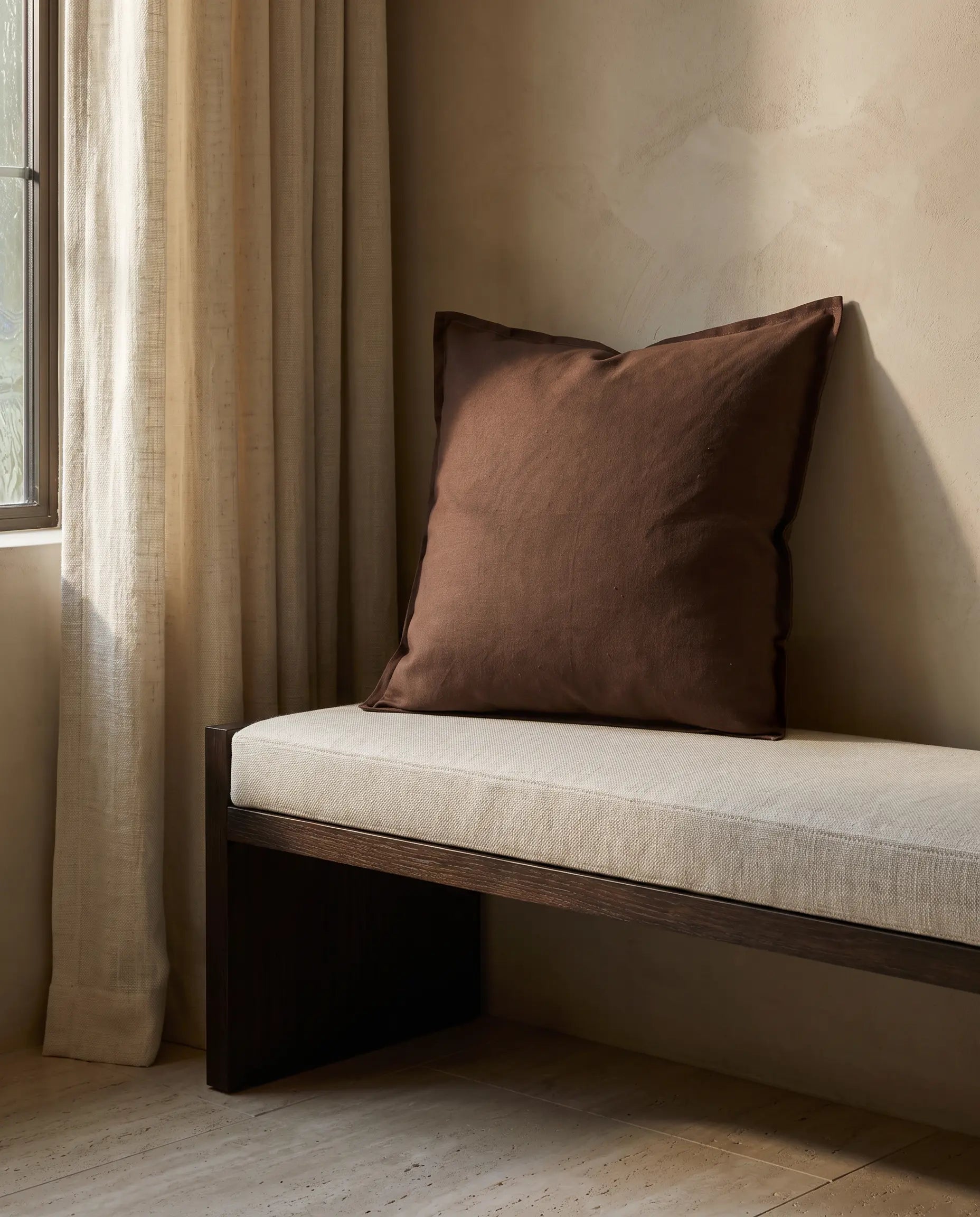Kuddfodral Classic Linen Duvblå 50x50 cm från Classic Collection i enfärgat linne, stylat på en ljusbeige dagbädd i en varm, neutral interiör.