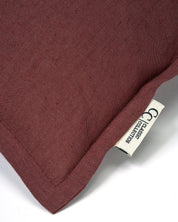 Kuddfodral Classic Linen Burgundy från Classic Collection i linne- och bomullsblandning, detaljbild av tygstruktur, söm och etikett.