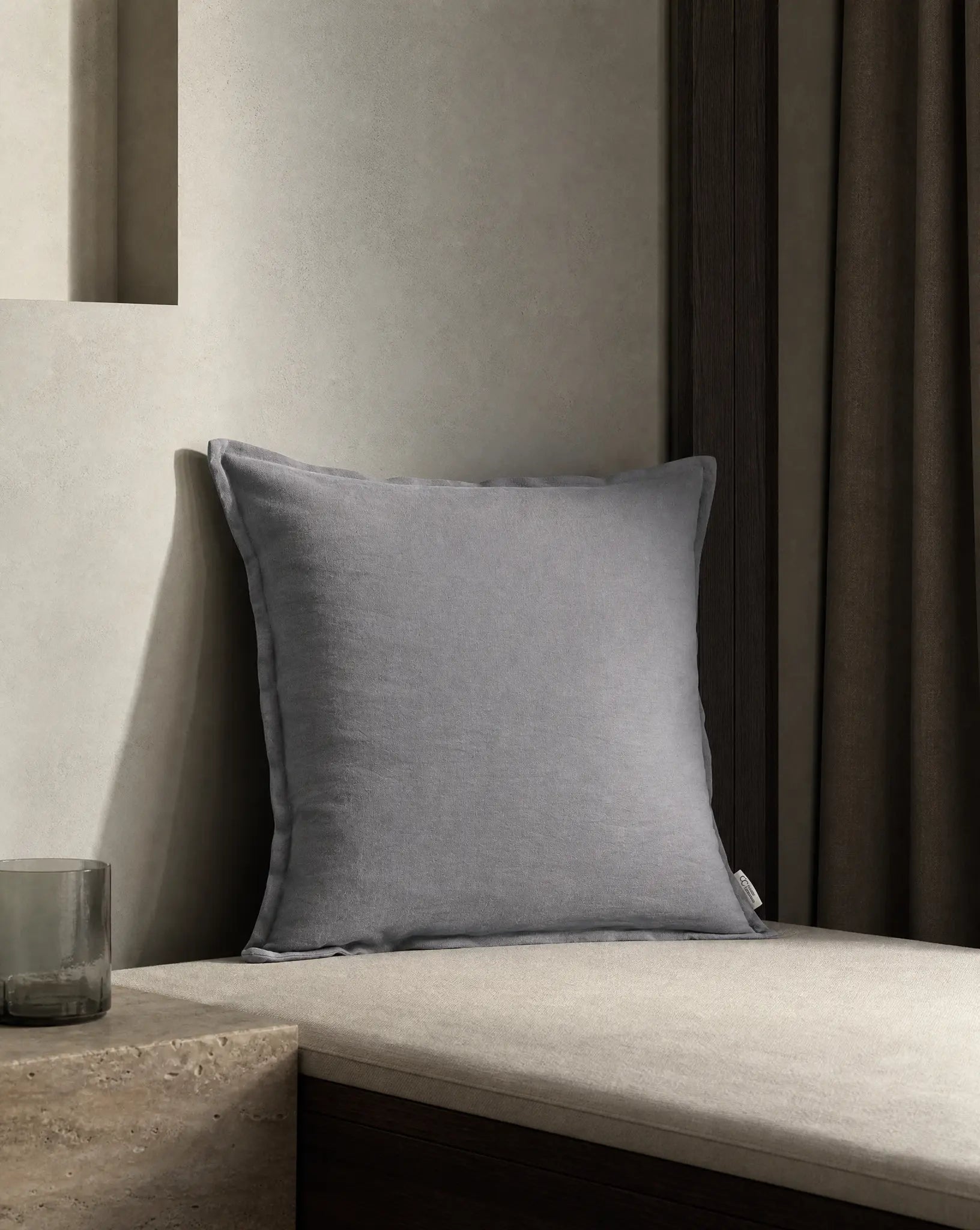 Kuddfodral Classic Linen Duvblå 50x50 cm från Classic Collection i enfärgat linne, stylat på en ljusbeige dagbädd i en varm, neutral interiör.