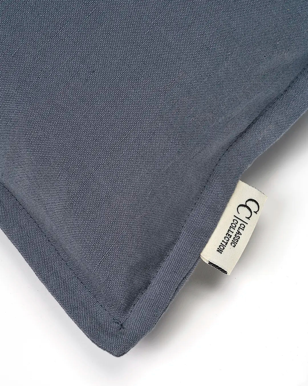 Close-up of a blue canvas cushion with a visible fabric texture and a branded Classic Collection tag.
