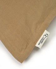 Tan woven fabric pillow cover with a Classic Collection brand label tag.