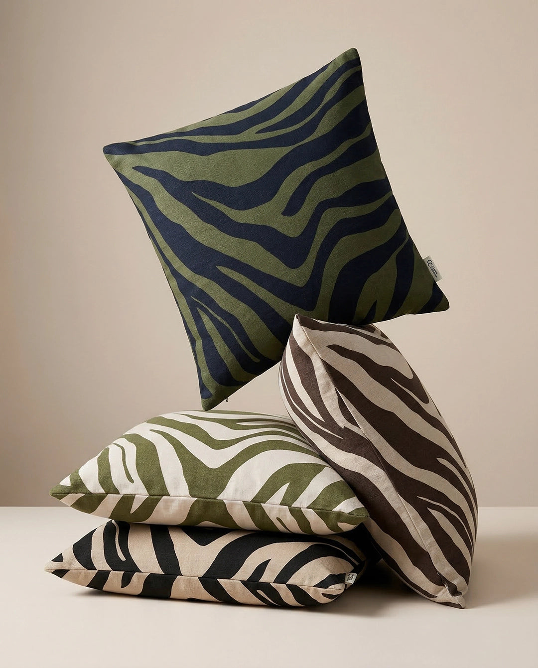 Stack of decorative square throw pillows with green, black, and tan zebra animal print patterns in soft cotton fabric.