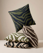 Stack of decorative square throw pillows with green, black, and tan zebra animal print patterns in soft cotton fabric.