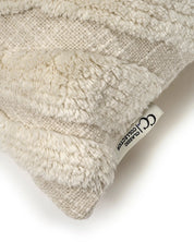 Cream-colored textured throw pillow with shaggy striped pattern and a Classic Collection brand tag.