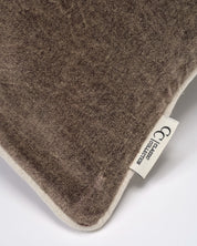 Närbild av Classic Velvet kuddfodral i mörk brun bomullssammet med tvättad yta, passpoalkant och synlig Classic Collection-etikett.