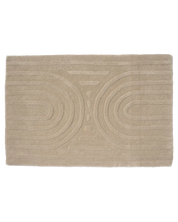 Rektangulär badrumsmatta i beige med mjuk textur och dekorativt, reliefmönstrat geometriskt vågmönster.