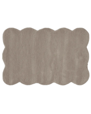 Rechteckiger, flauschiger Teppich in Beige mit geschwungenem, gewelltem Rand im organischen Design.