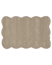 Rechteckiger, beigefarbener Badteppich mit weichem Flor und wellenförmigem Rand.