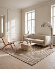 Handtuftad ullmatta Zebra Beige från Classic Collection med grafiskt zebramönster i beige och off-white, placerad i ett ljust vardagsrum med soffa, fåtölj och soffbord.