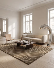 Handtuftad ullmatta Zebra Mocca från Classic Collection med grafiskt zebramönster i bruna och beiga toner, placerad i ett ljust vardagsrum med soffa, fåtölj och soffbord.