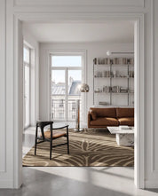 Handtuftad ullmatta Zebra Mocca från Classic Collection med grafiskt zebramönster i bruna och beige toner, placerad i ett ljust vardagsrum med cognacsfärgad soffa, fåtölj och marmorbord.