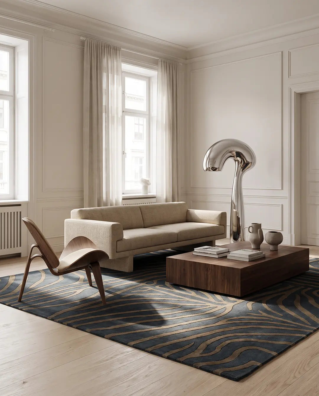 Handtuftad ullmatta Zebra Horizon från Classic Collection med grafiskt zebramönster i gråblå och beige toner, placerad i ett ljust vardagsrum med soffa, loungestol och soffbord.