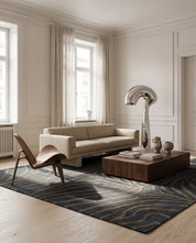 Handtuftad ullmatta Zebra Horizon från Classic Collection med grafiskt zebramönster i gråblå och beige toner, placerad i ett ljust vardagsrum med soffa, loungestol och soffbord.