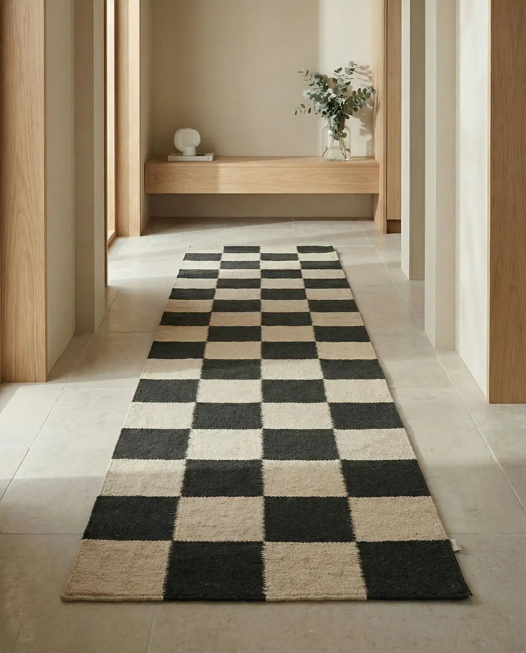 Langer Flurläufer mit modernem Schachbrettmuster in Schwarz und Beige in einem minimalistisch eingerichteten Flur.