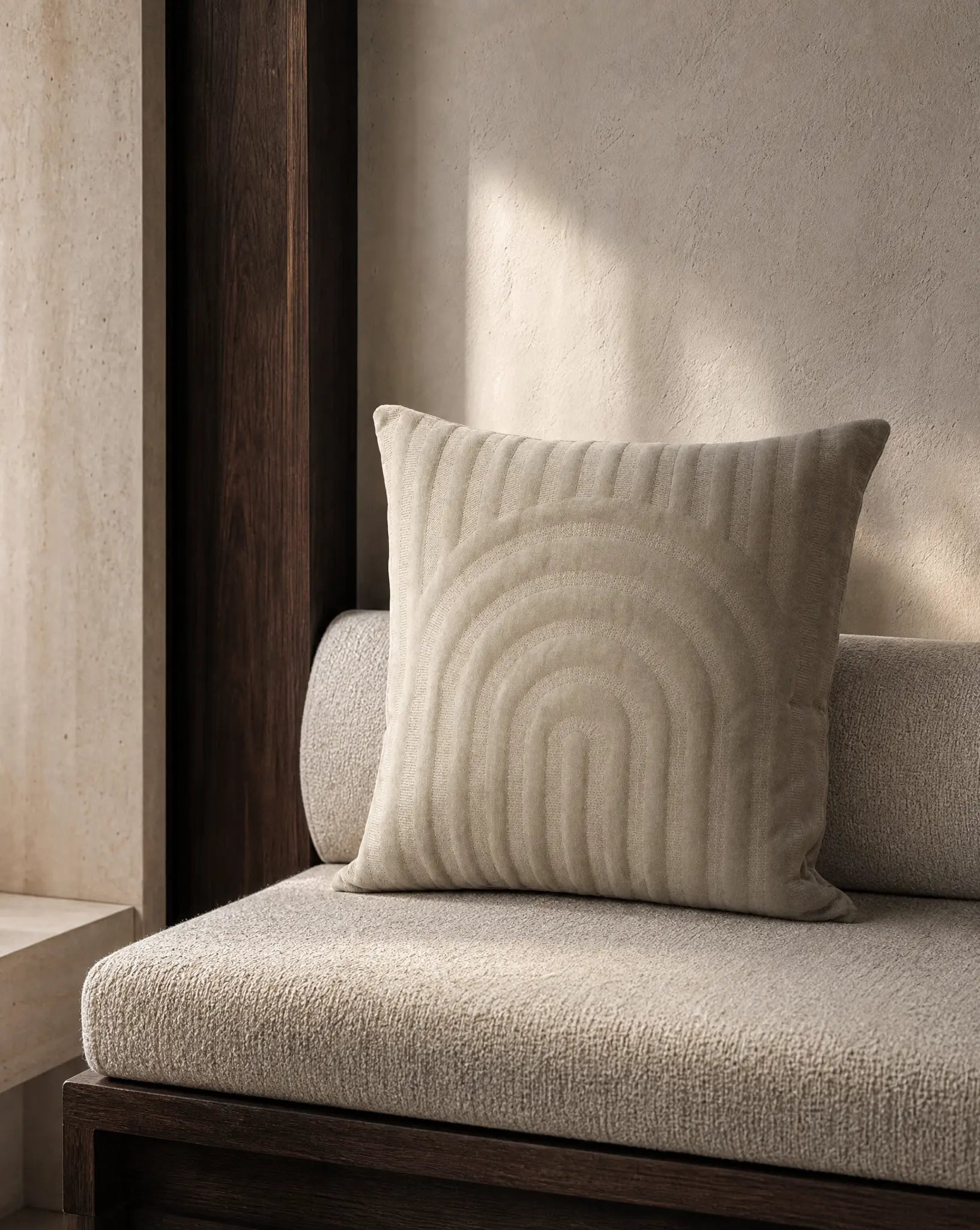 Kuddfodral Arch Simply Taupe 50x50 cm från Classic Collection i enfärgat bomullssammet, stylat på en beige soffa i en varm, neutral interiör.