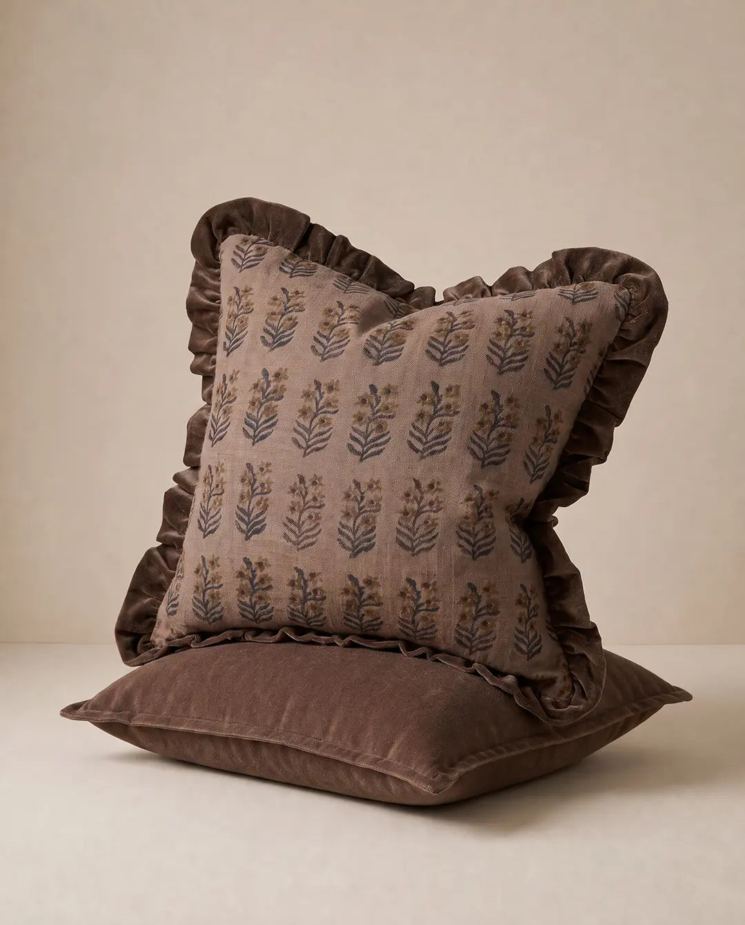 Kuddfodral Tamarind Aubergine och Classic Velvet Brun från Classic Collection, handgjorda i bomull och bomullssammet, stylade tillsammans mot en neutral bakgrund.