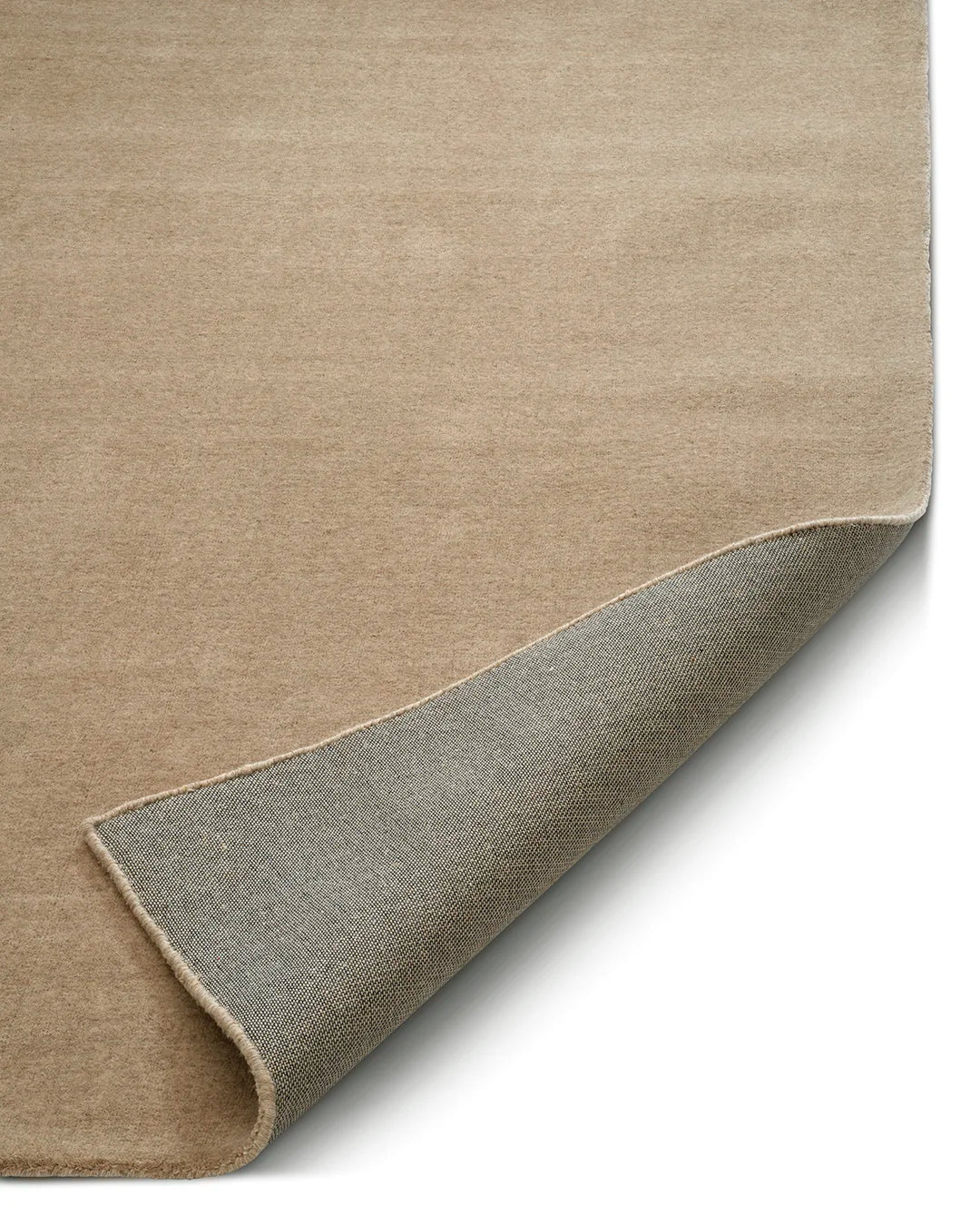 Närbild på handvävd ullmatta Lodge i färgen Natural Beige från Classic Collection, med mjuk melerad lugg och synlig baksida.