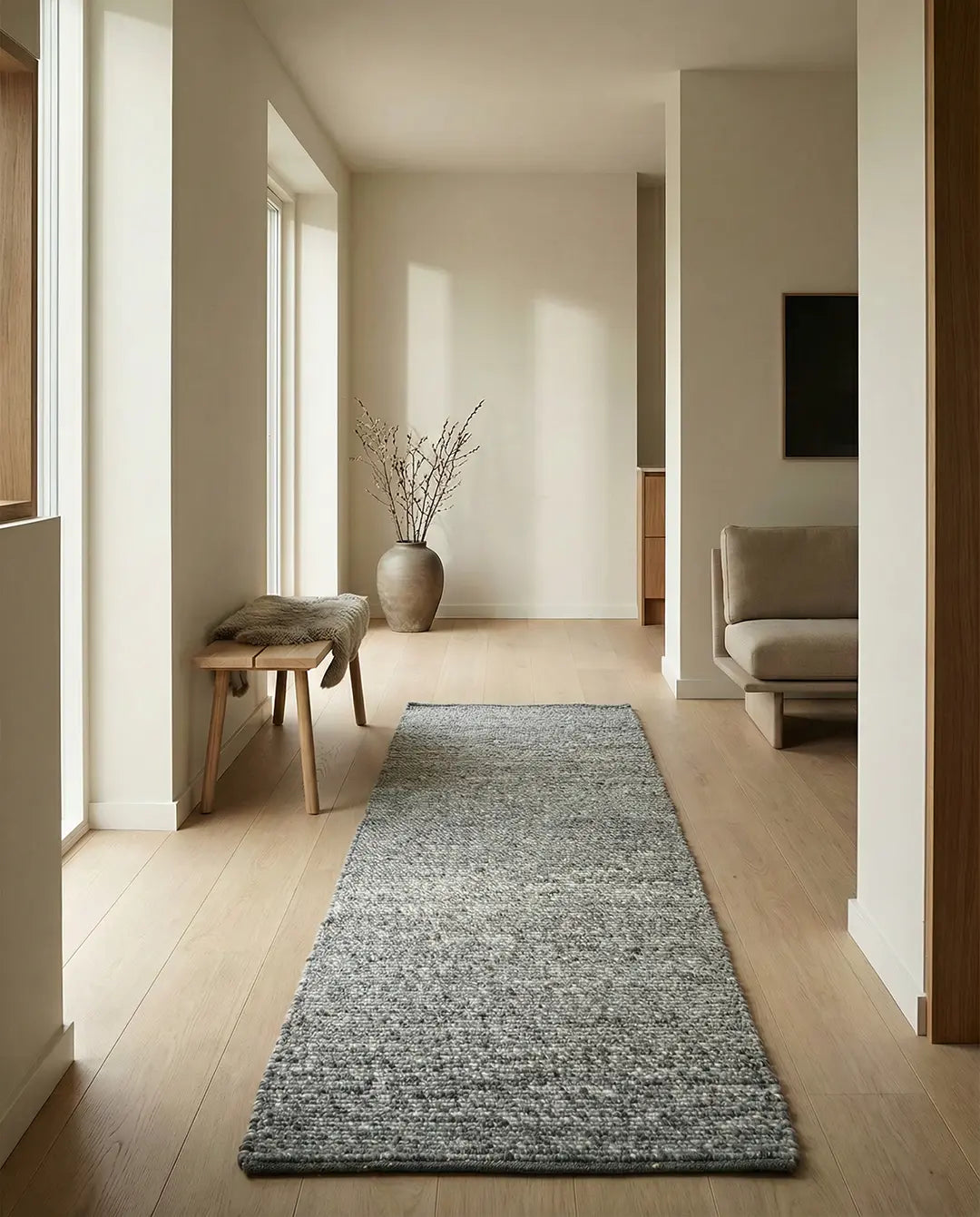Grauer, strukturierter Läufer im minimalistisch eingerichteten Flur mit Holzboden.