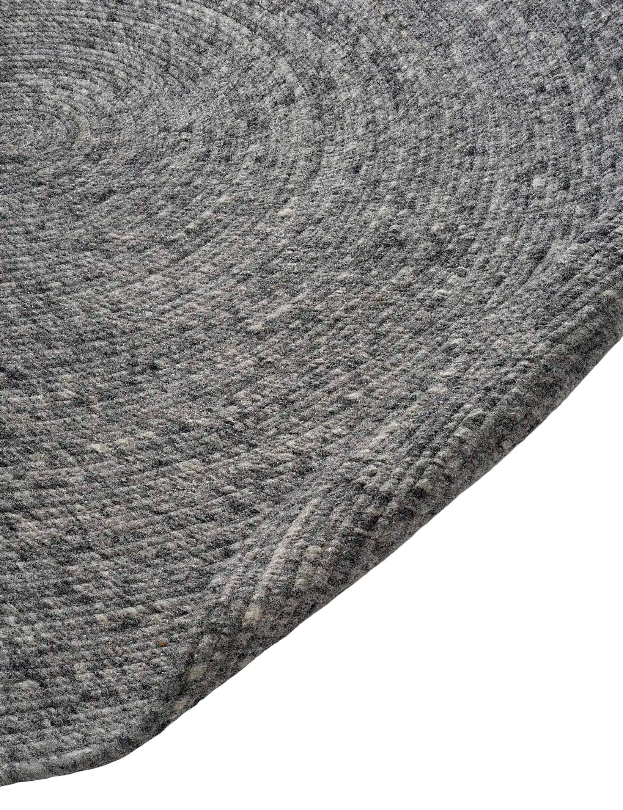 Close-up of a charcoal grey round braided wool area rug with a textured, spiral weave design.