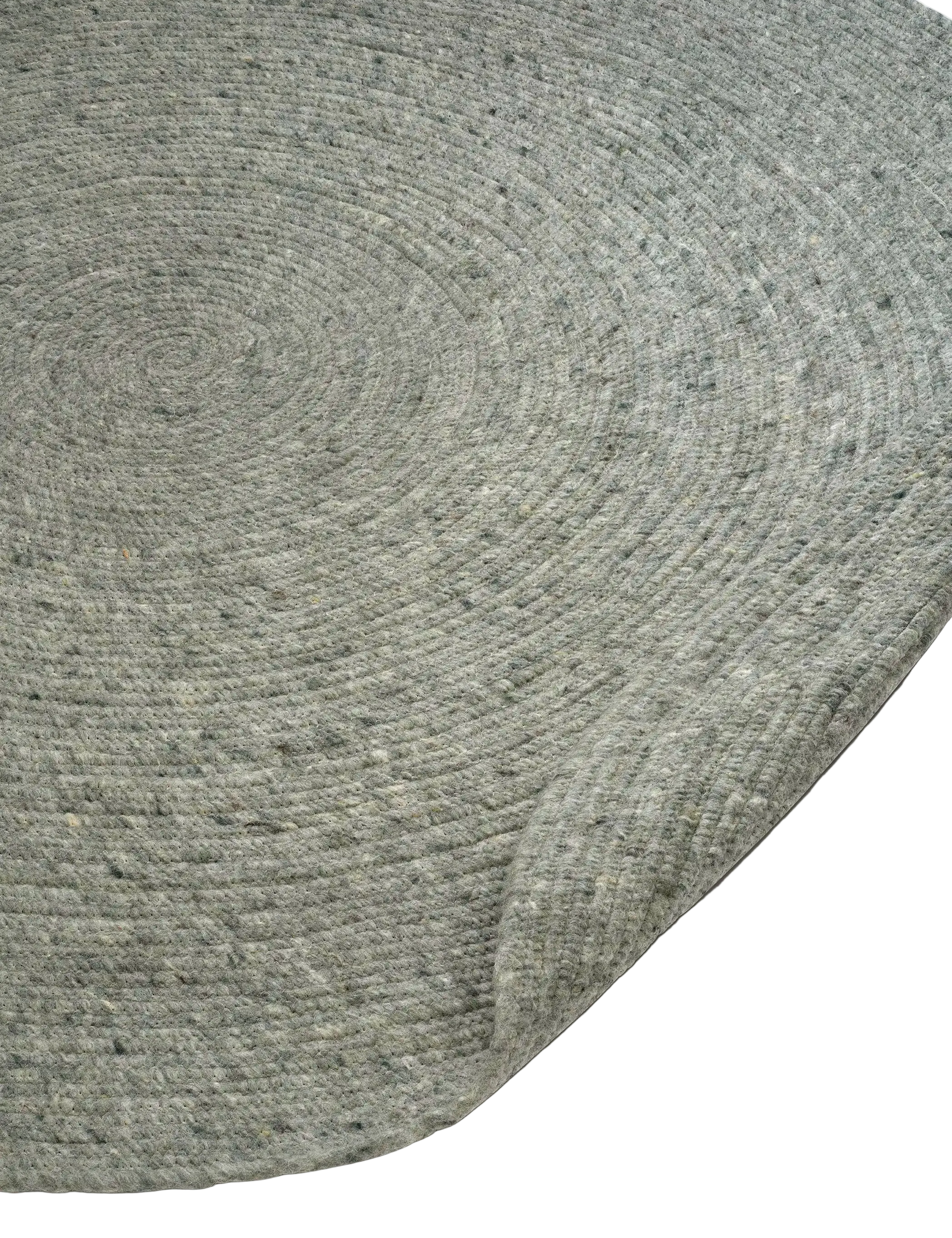 Detaljbild av rund ullmatta Merino i grön ull som visar vävstruktur och jämn, rund kant.