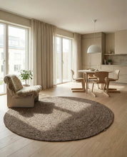 Runder, beige geflochtener Juteteppich in einem modern eingerichteten, hellen Wohn-Esszimmer.
