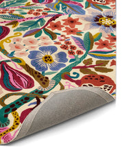 Närbild på Matta Pomegranate handtuftad i ull, visar detalj av blommor, blad och granatäpplen samt mattans baksida.