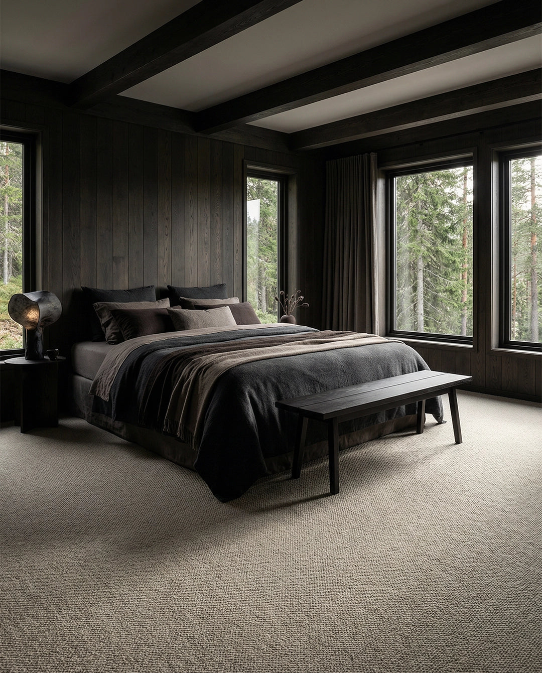 Luxuriöses Schlafzimmer mit dunkelgrauer Bettwäsche, Holzvertäfelung und hellem strukturiertem Teppichboden.
