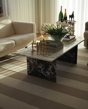 Handtuftad ullmatta Stripe Bouclé Ivory/Beige i vardagsrum under marmorbord, med breda ränder i ivory och beige.