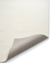 Närbild av ullmatta Lobby Off-white från Classic Collection med uppvikt hörn som visar mattans undersida, kantavslut och täta väv.