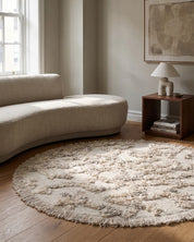 Rio Rund Ivory/Melange från Classic Collection, handvävd ullmatta 220 cm i diameter, placerad i vardagsrum med ljus soffa och trädetaljer.