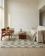 Moderner Wohnzimmerteppich mit grün-beigem Schachbrettmuster in einem hellen, minimalistischen Interieur.