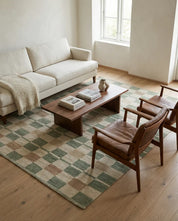 Teppich mit kariertem Muster in Grün, Beige und Braun in einem modern eingerichteten Wohnzimmer mit Ledersesseln.
