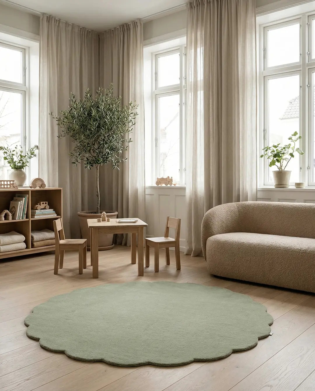 Scalloped sage green round area rug in a modern Scandinavian living room with wooden furniture and neutral decor.