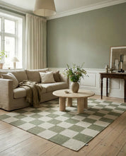 Moderner Wohnzimmerteppich mit grün-weißem Schachbrettmuster in einem hellen, skandinavischen Wohnraum.