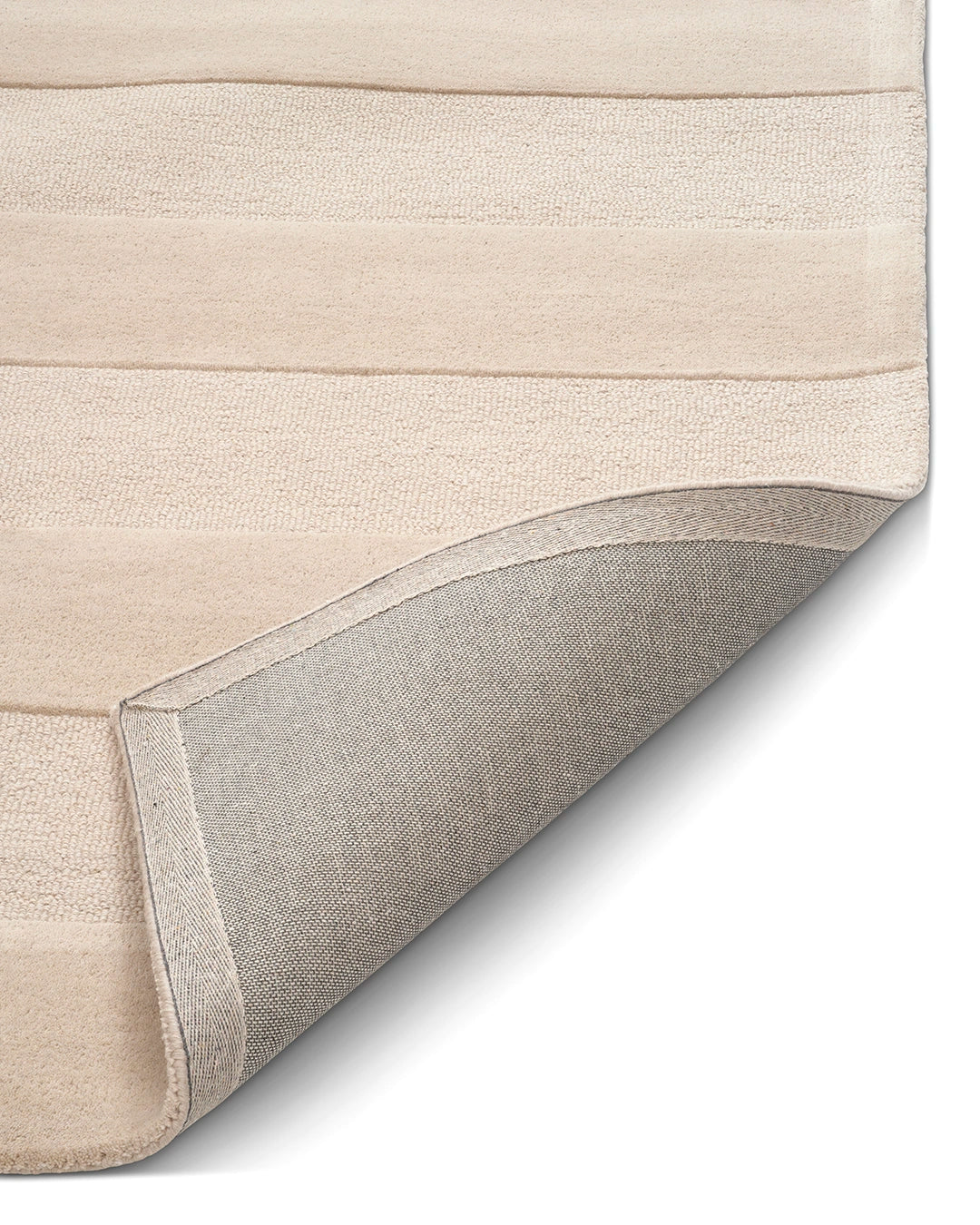 Närbild av beige Stripe Bouclé-matta med randig struktur och uppvikt hörn som visar mattans vävda baksida.