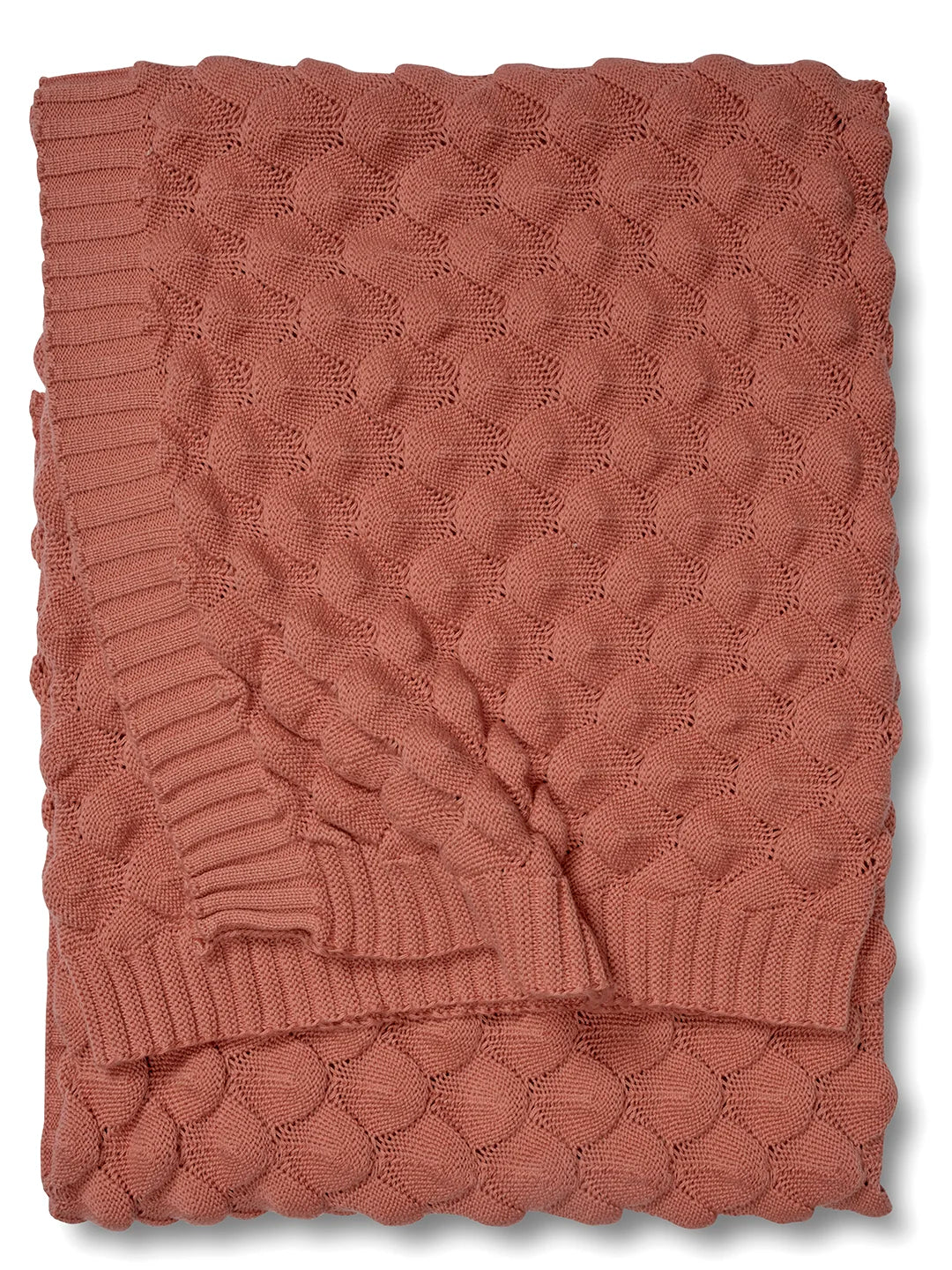 Korallfärgad pläd i bomull, 130x170 cm. Vikt mot vit bakgrund. Stickat mönster.