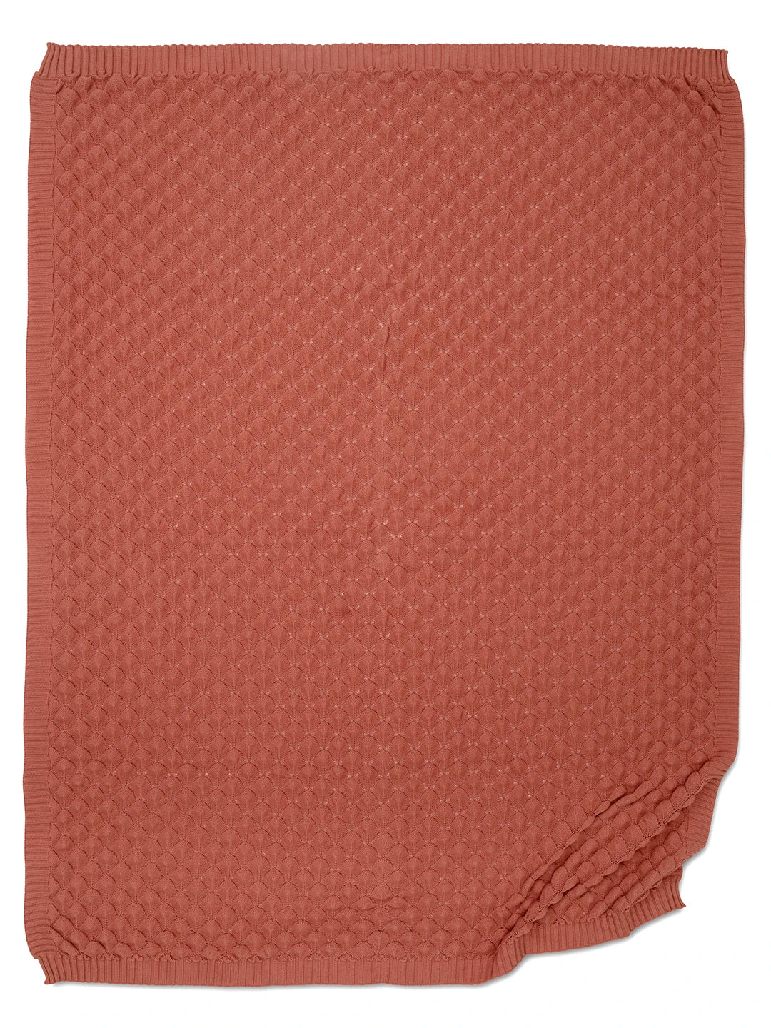 Korallfärgad pläd i bomull, 130x170 cm. Foto på hela pläden mot vit bakgrund. Stickat mönster.