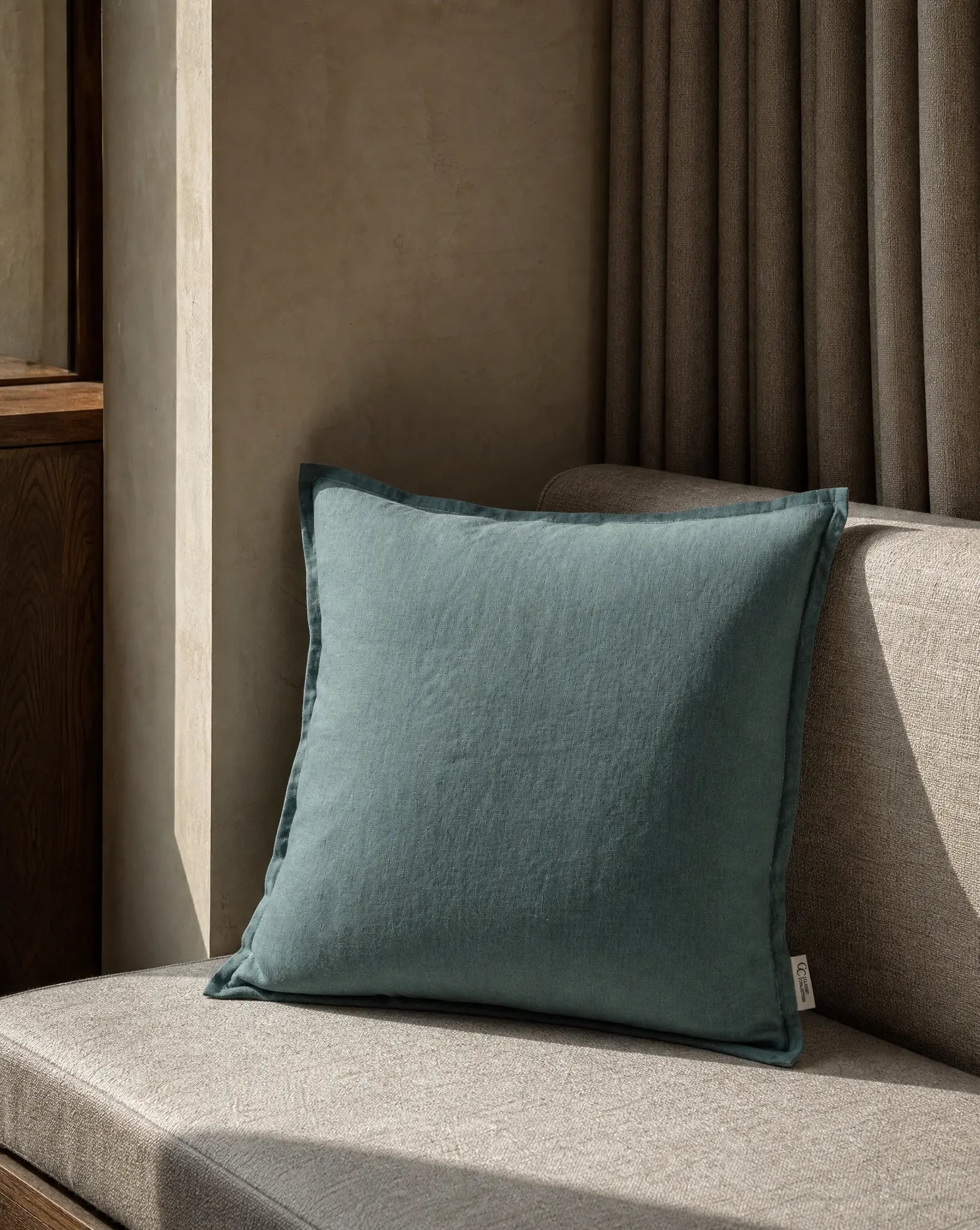 Kuddfodral Classic Linen Teal 50x50 cm från Classic Collection i enfärgat linne, stylat på en ljus soffa i en varm, neutral inredning.