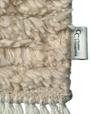 Hochfloriger, beiger Wollteppich mit Fransen und Classic Collection Etikett in Nahaufnahme.