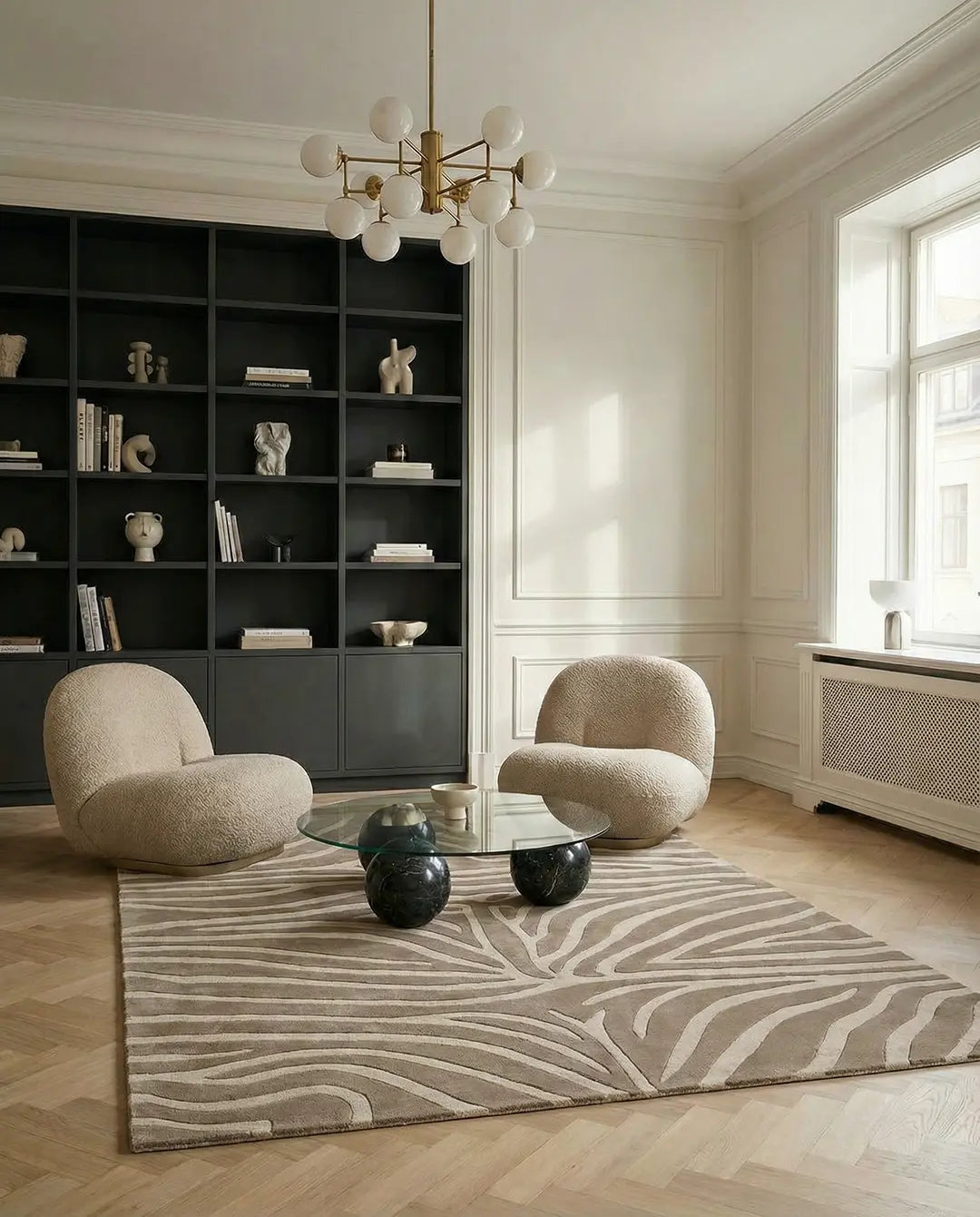 Två beige bouclé-fåtöljer vid ett soffbord med glastopp och marmorfötter på en mönstrad matta i ett modernt vardagsrum.