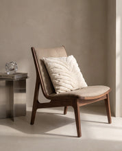 Kuddfodral Classic Zebra Tuft 50x50 cm från Classic Collection i enfärgat bomull med taktilt mönster, stylat i en ljus fåtölj i en varm, neutral interiör.