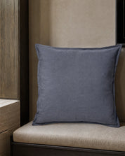 Kuddfodral Classic Linen Midnattsblå 50x50 cm från Classic Collection i enfärgat linne, stylat på en ljusbeige bänk i en varm, neutral interiör.